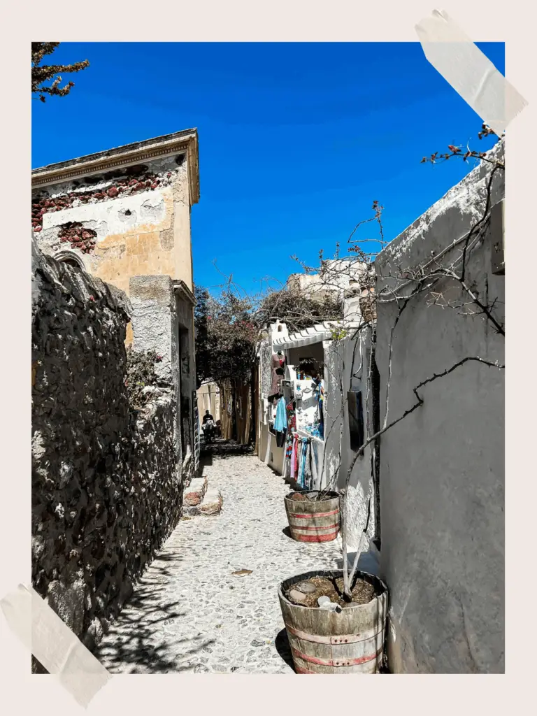 Santorini architecture - weaving through whitewashed buildings, under the Mediterranean sun.