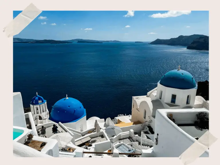 Santorini architecture. Greek Islandi: Blue-domed churches set against whitewashed buildings and the Aegean Sea.