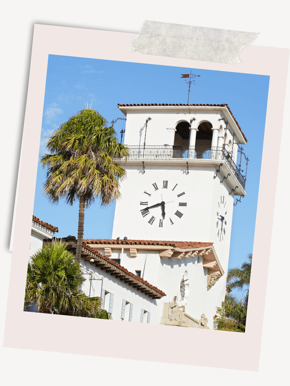 The exterior of the clock tower at the Santa Barbara Courthouse, standing tall under a bright blue sky, with its intricate Spanish Colonial design and red-tiled roof illuminated by the sunlight.